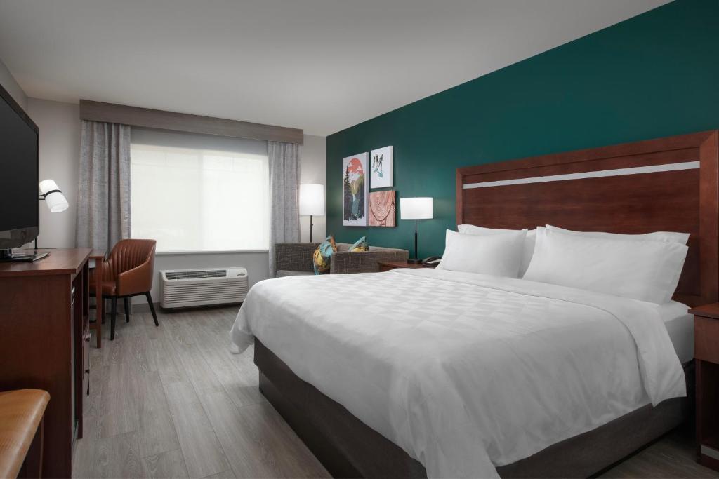 a hotel room with a large bed and a desk at Holiday Inn & Suites Durango Downtown by IHG in Durango