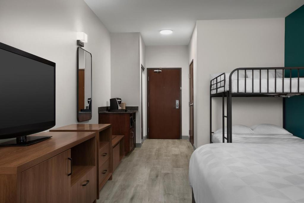 a bedroom with a bunk bed and a flat screen tv at Holiday Inn & Suites Durango Downtown by IHG in Durango
