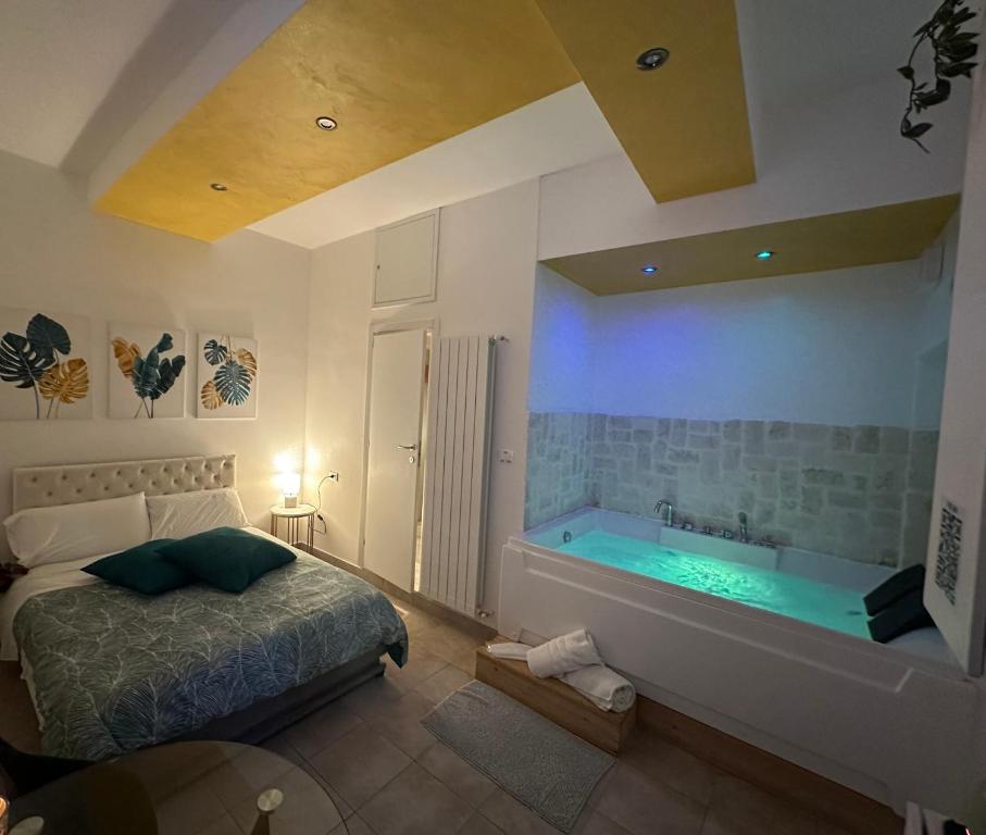 a bedroom with a bed and a bath tub at Le Plaisir Luxury Room con vasca idromassaggio in Martina Franca