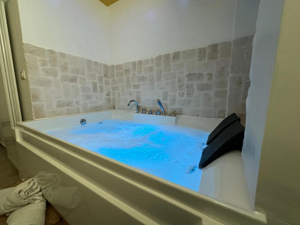 a bath tub with blue water inside of it at Le Plaisir Luxury Room con vasca idromassaggio in Martina Franca