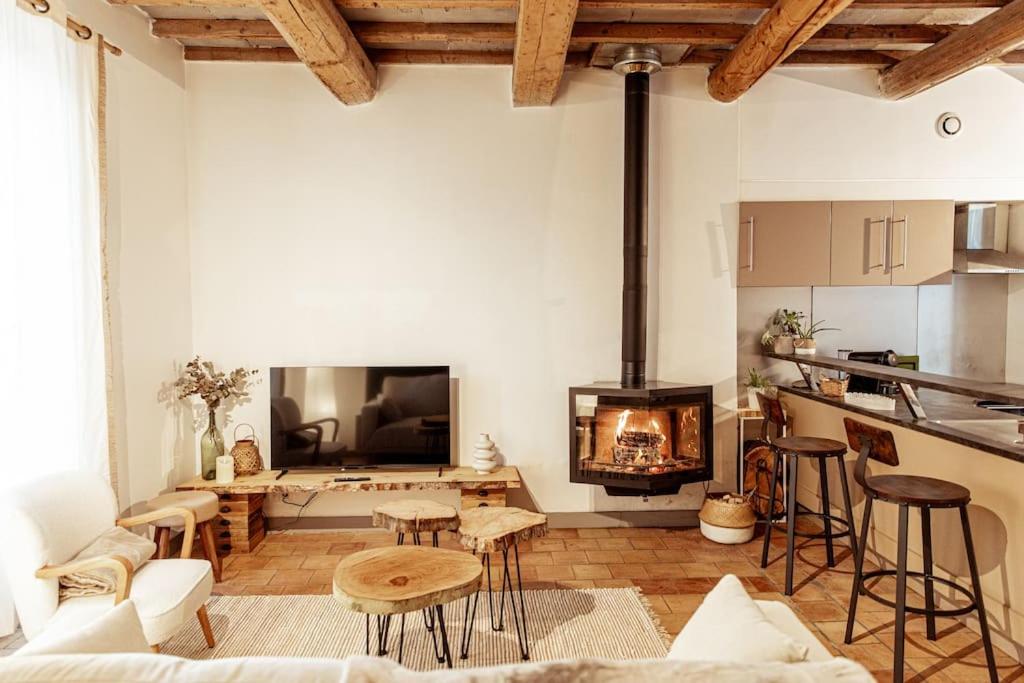 a living room with a fireplace and a table at Maison de village Barbentane avec spa in Barbentane