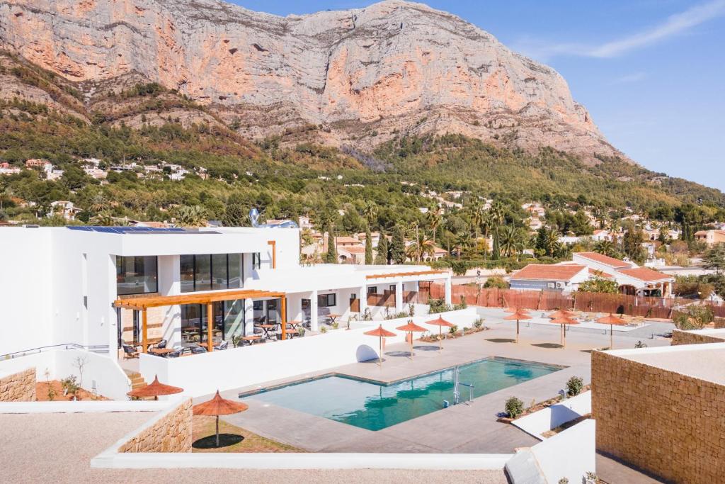 a building with a pool and a mountain in the background at Hotel Boutique Mi Almazara in Jávea