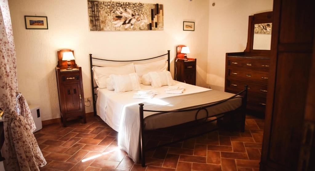 1 dormitorio con 1 cama con sábanas blancas y 2 mesitas de noche en Nature & Relax in Tuscany - Fresco 2, en Roccastrada