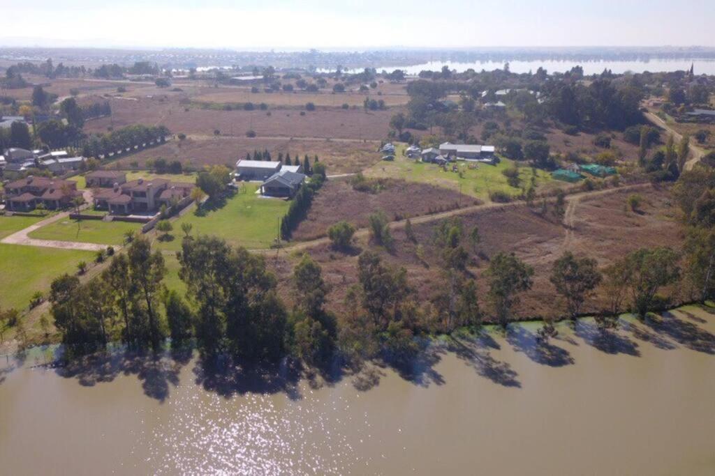 an aerial view of a house next to a lake at Vaaldam @ Sgt Pepper’s Holiday Home in Oranjeville