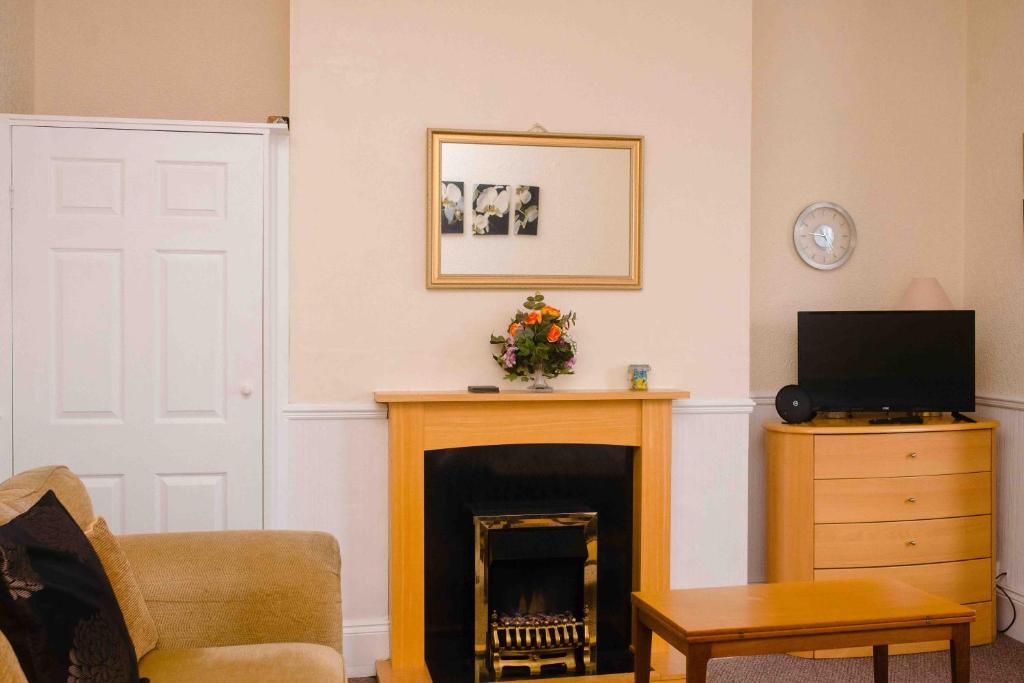 a living room with a fireplace and a television at THE CHADWICK in Skegness