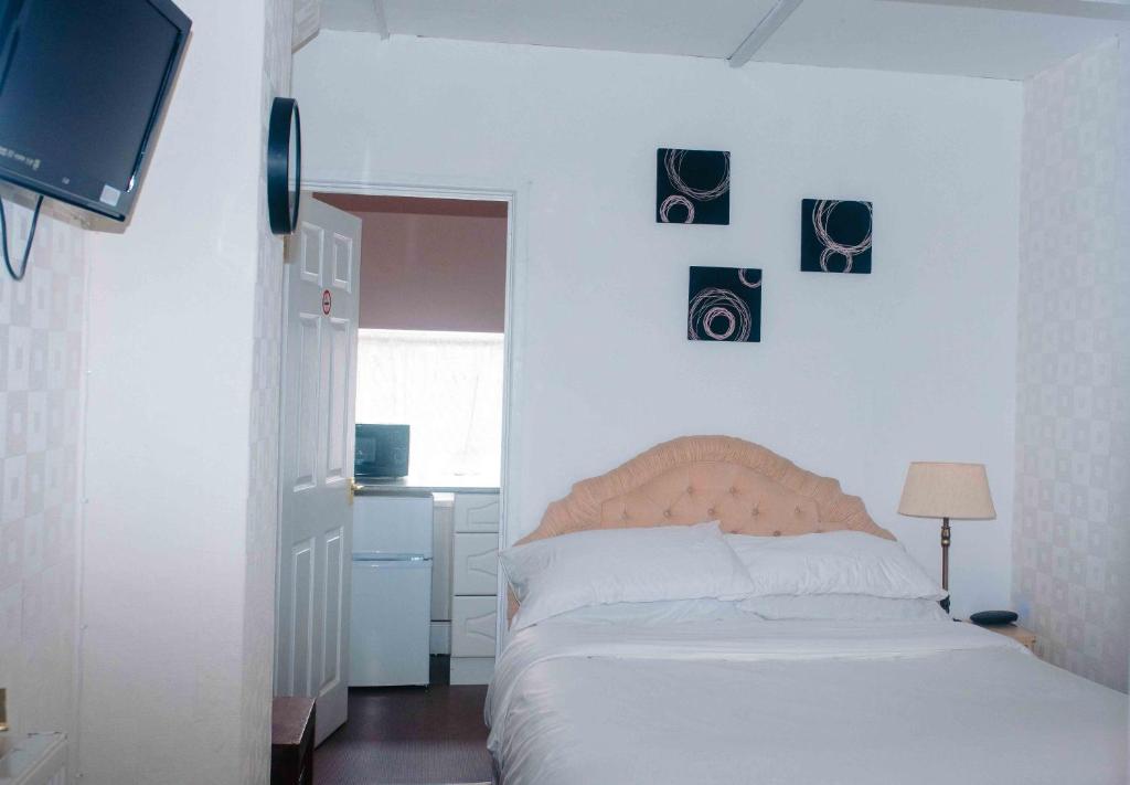 a bedroom with a bed with pictures on the wall at THE CHADWICK in Skegness