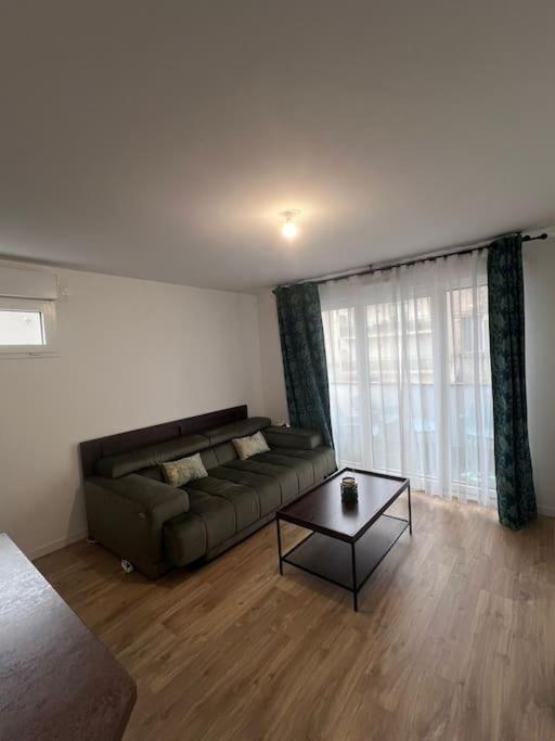 un salon avec un canapé et une table basse dans l'établissement Appartement 5 personnes, à Pierrefitte-sur-Seine