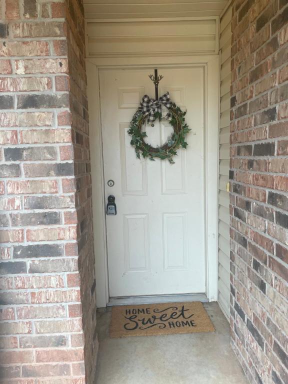 Una porta bianca con una corona di Natale sopra. di And Boots Start Knocking a Stillwater