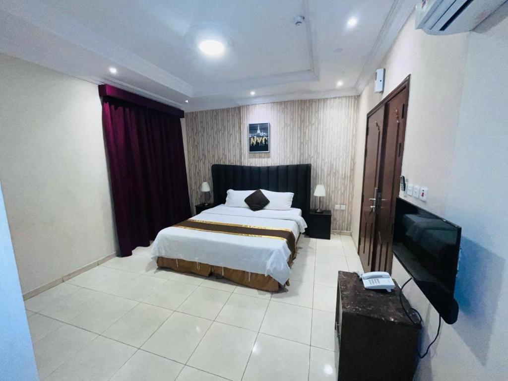 1 dormitorio con 1 cama y TV de pantalla plana en شقة الفخامة en Yeda