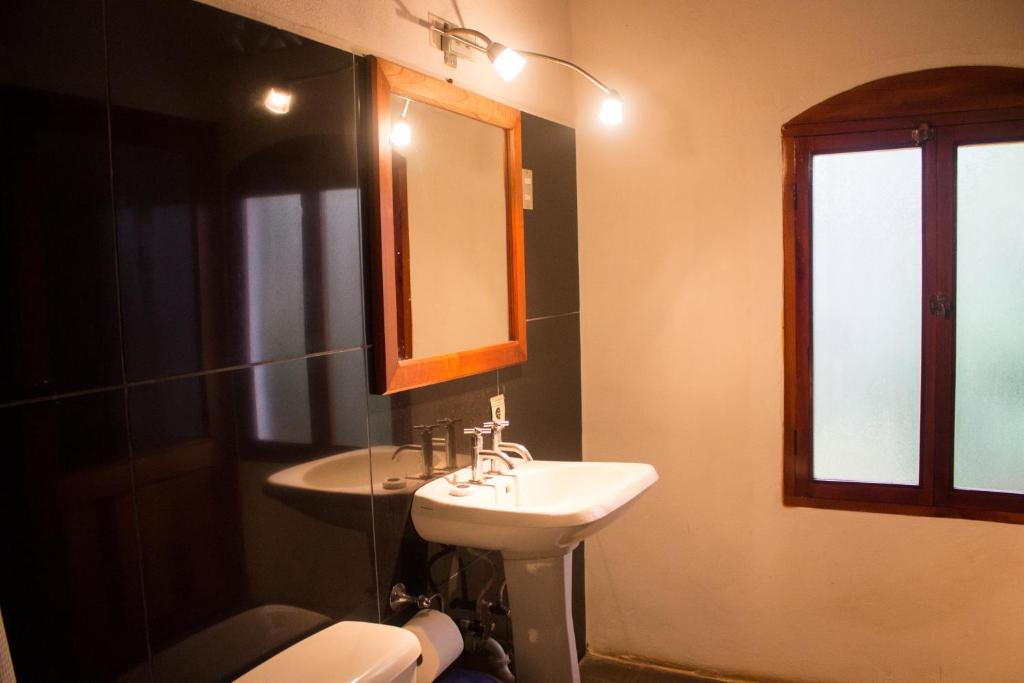 a bathroom with a sink and a toilet and a mirror at Hotel il Padrino in Granada