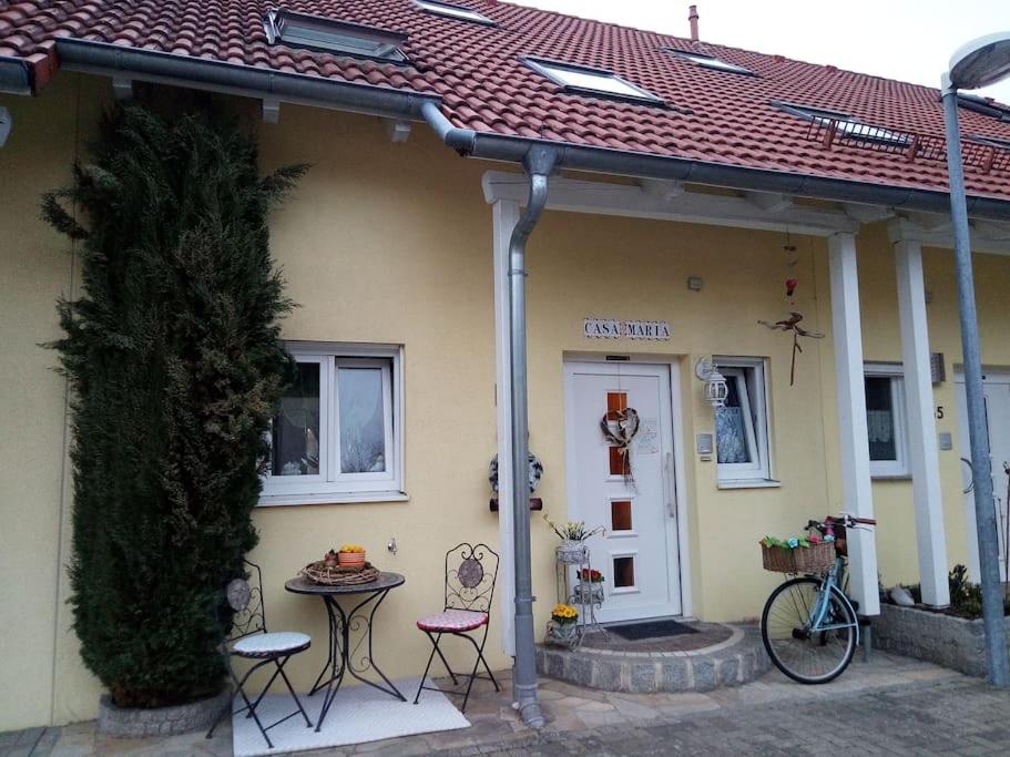 een huis met twee stoelen en een tafel ervoor bij Casa Maria in Weingarten