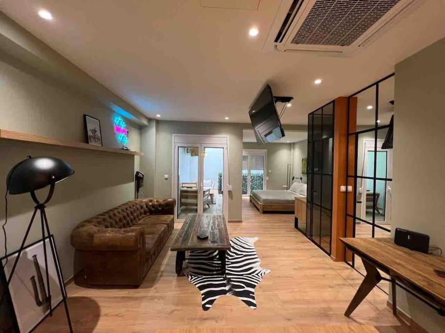 a living room with a couch and a table at Hidden Garden of Kallithea in Athens