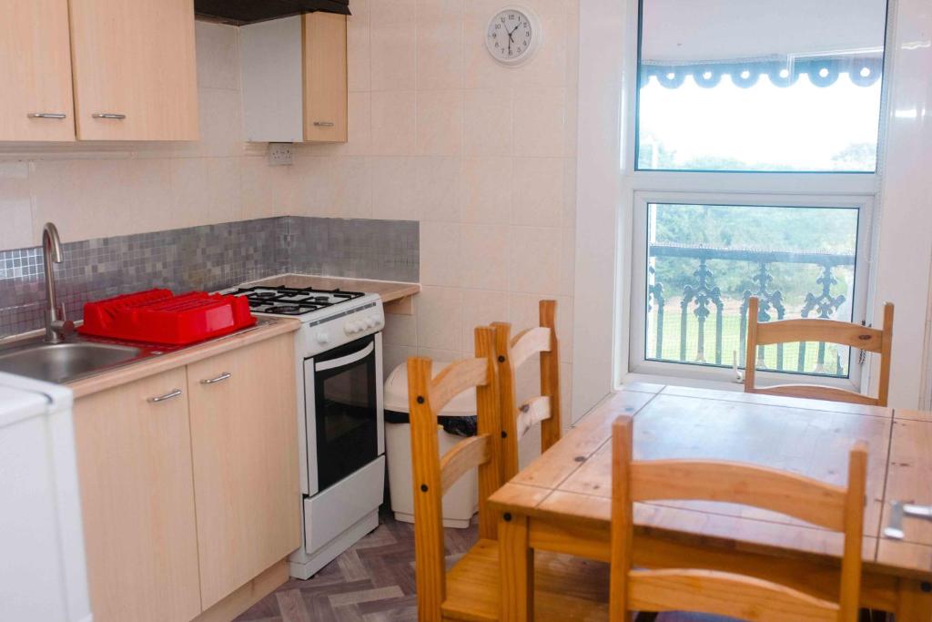 a kitchen with a stove and a table with chairs at THE CHADWICK in Skegness