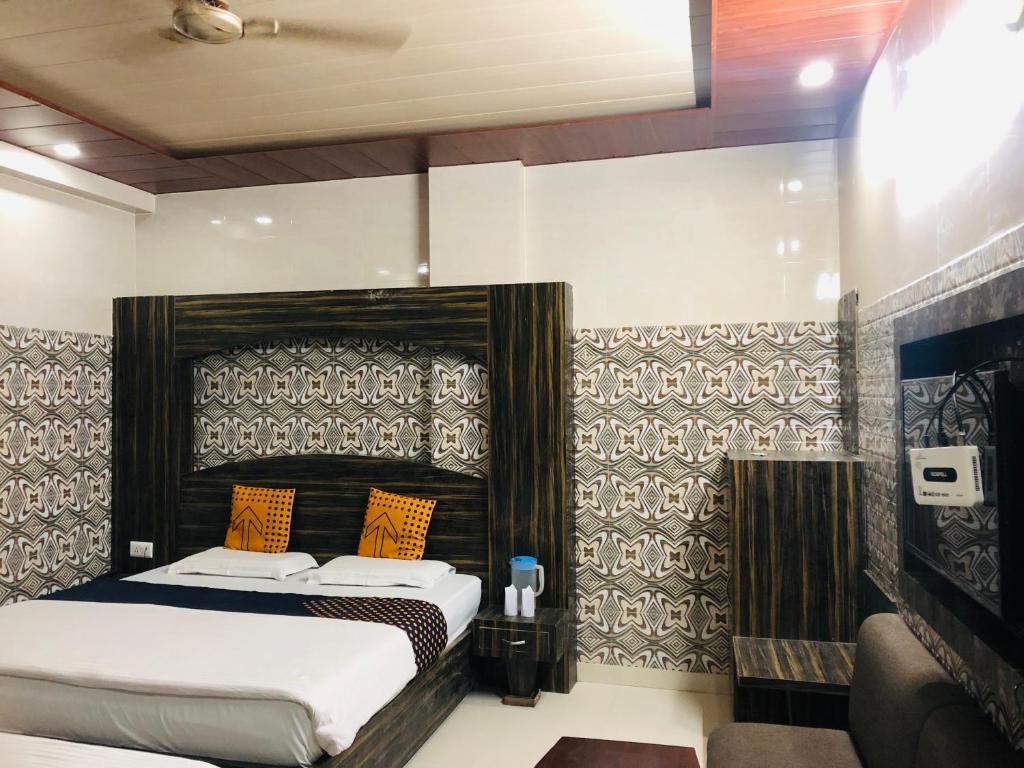 - une chambre avec un lit et des oreillers orange dans l'établissement Vidya hotel, à Katra