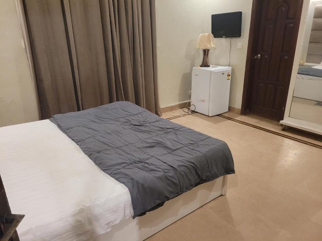 Un dormitorio con una cama con una manta azul. en Cottage Hotel, en Karachi