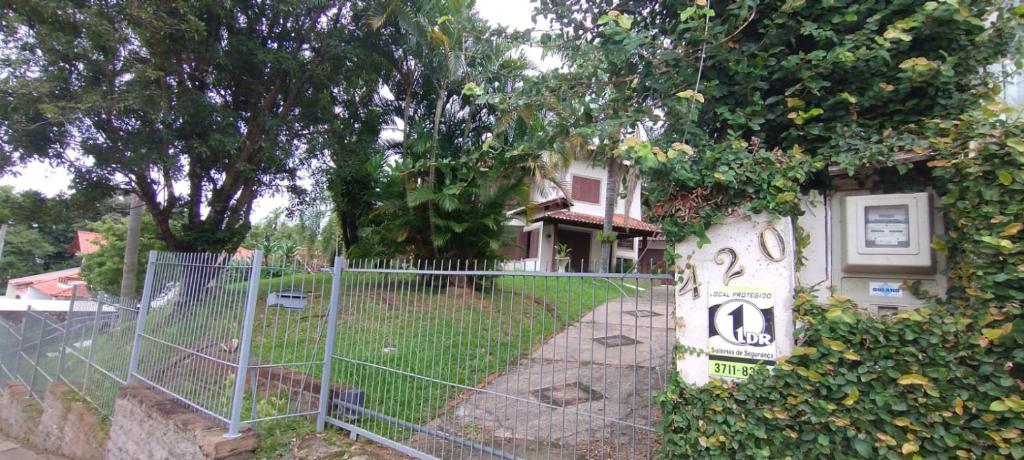 uma cerca em frente a uma casa com um sinal em Hostel de Gaia em Santa Cruz do Sul