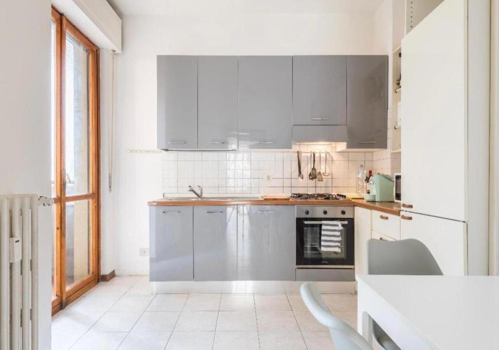 eine weiße Küche mit weißen Geräten und einem Fenster in der Unterkunft Appartamento76 in Florenz
