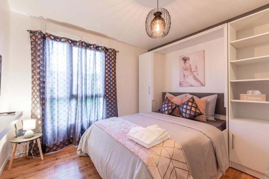 a bedroom with a bed and a large window at NeuvaRoom in Montévrain