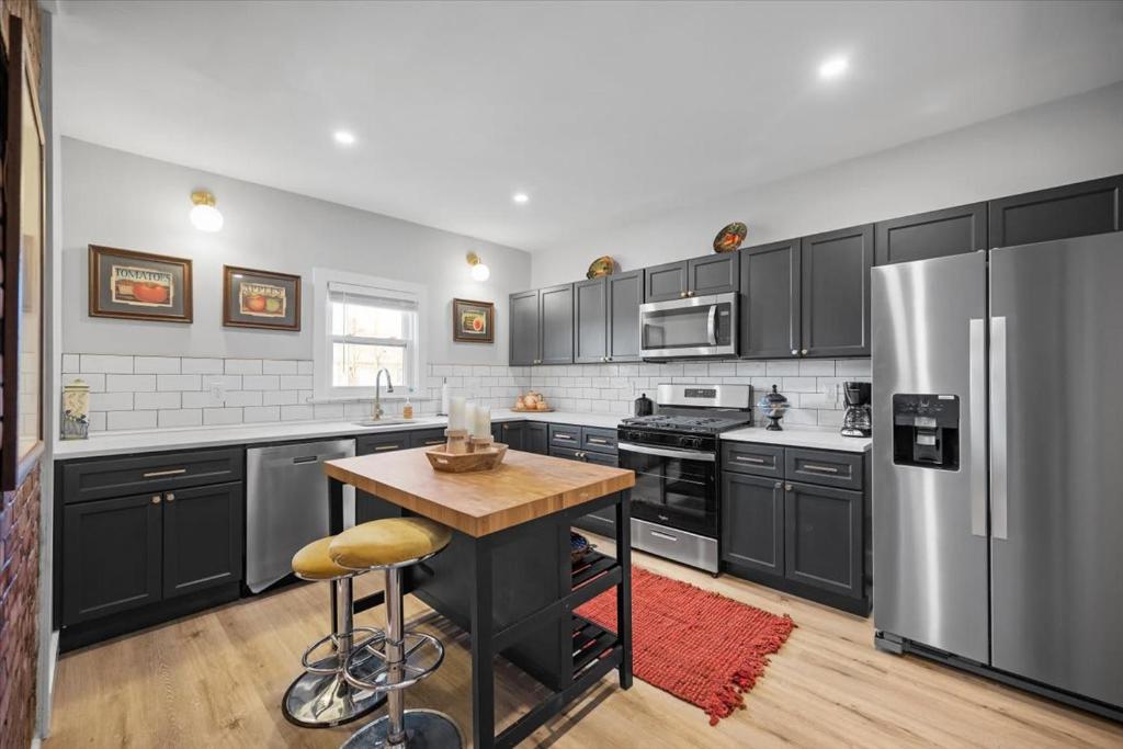 a kitchen with stainless steel appliances and a wooden table at Classic Pittsburgh 4 Square - Easy Access to Town and Airport in Pittsburgh