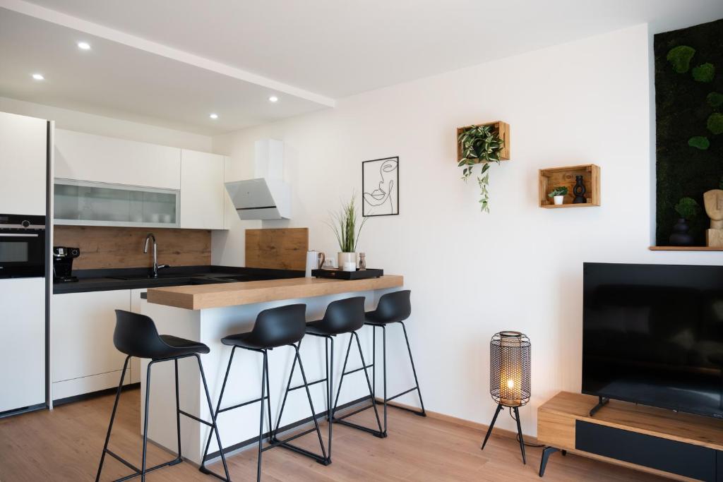 a kitchen with a bar with stools and a tv at MH Living - 22 - Scandinavian Living Dream in Center in Graz