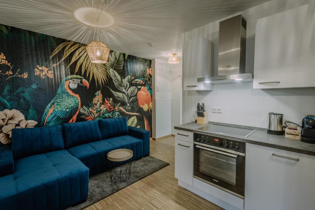 uma sala de estar com um sofá azul numa cozinha em Passaus Motto Appartements! Solo - Pärchen - Familien - Gruppen em Passau