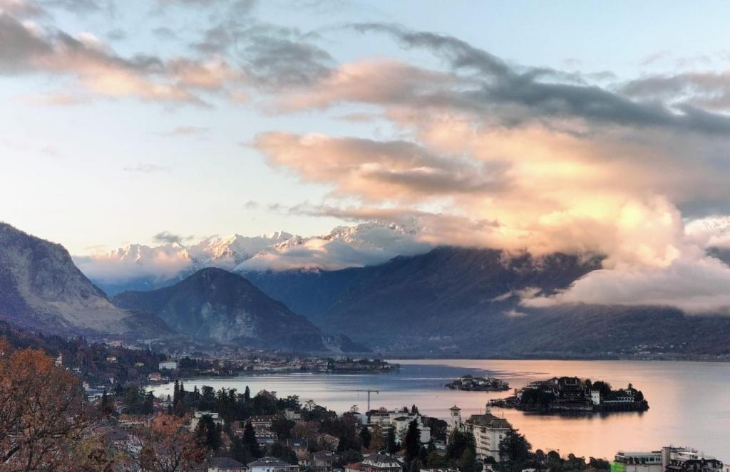 a view of a lake with a city and mountains at Panorama Loft Apartments in Stresa