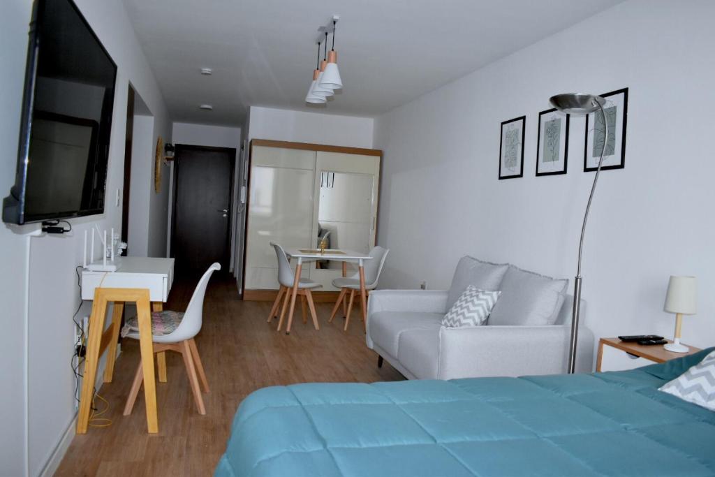 um quarto com uma cama, um sofá e uma mesa em Hermoso apartamento a 150 metros de la rambla em Montevidéu