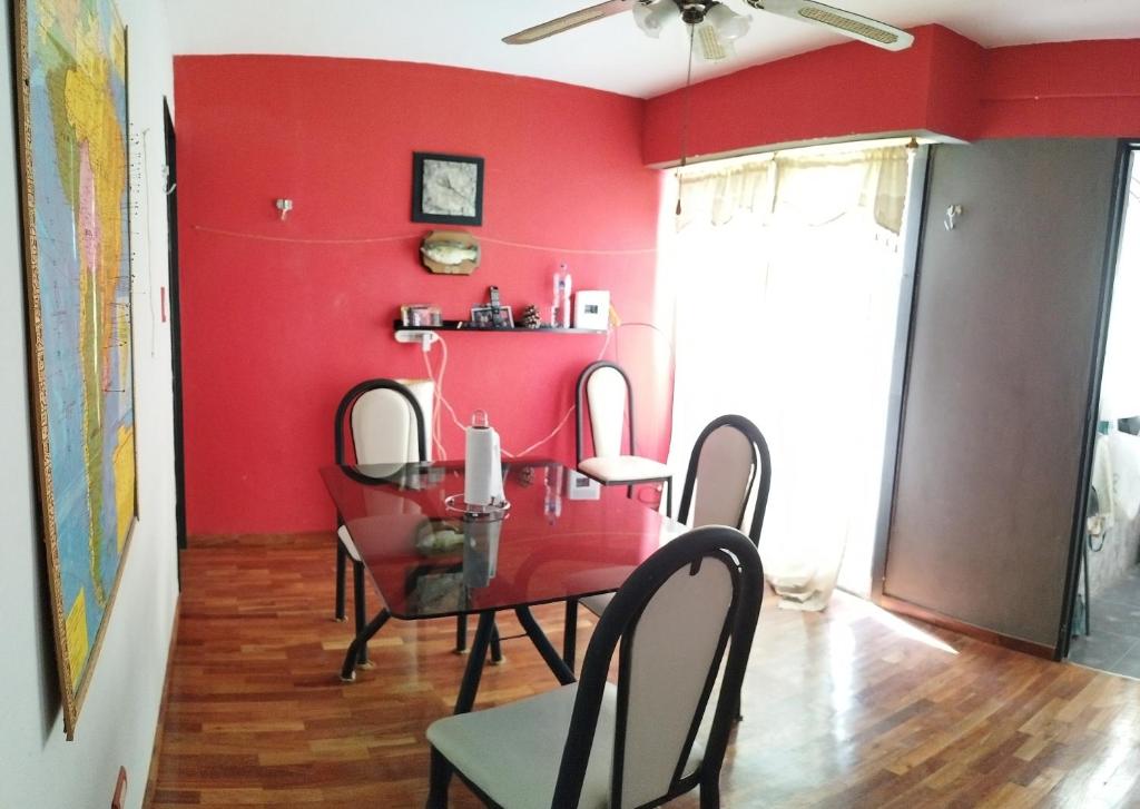 a dining room with red walls and a table and chairs at Departamento 2 ambientes in Buenos Aires