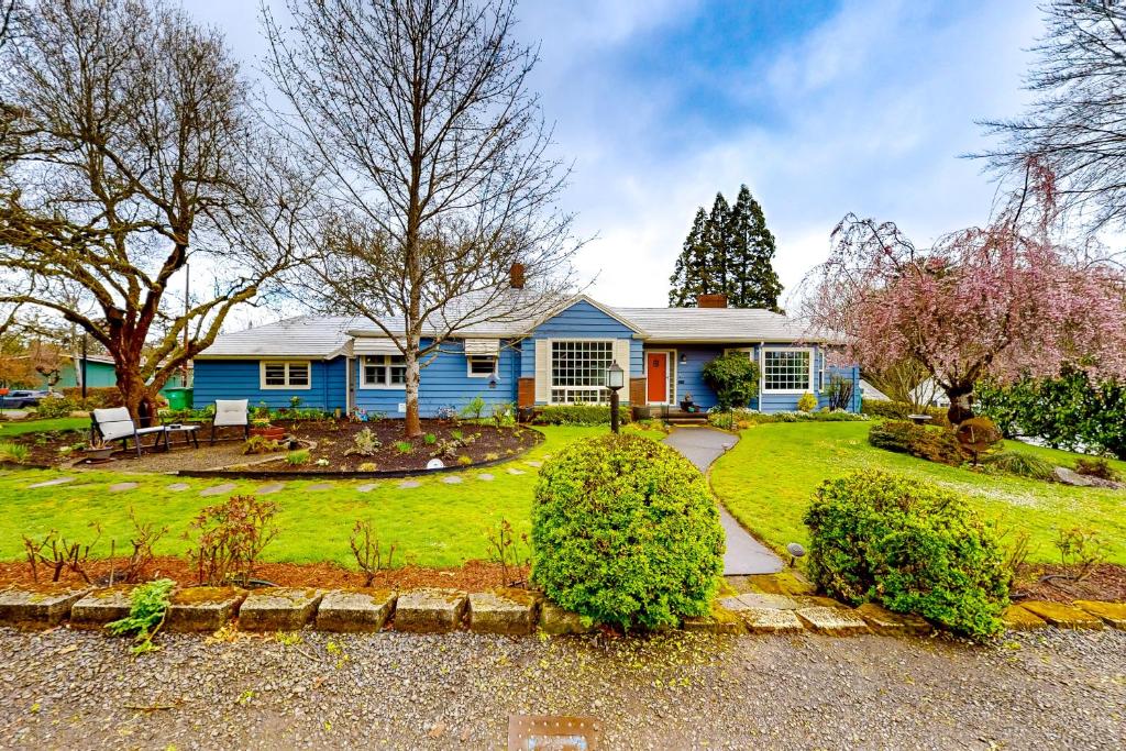 a blue house with a garden in front of it at Multnomah Village Hideaway in Portland