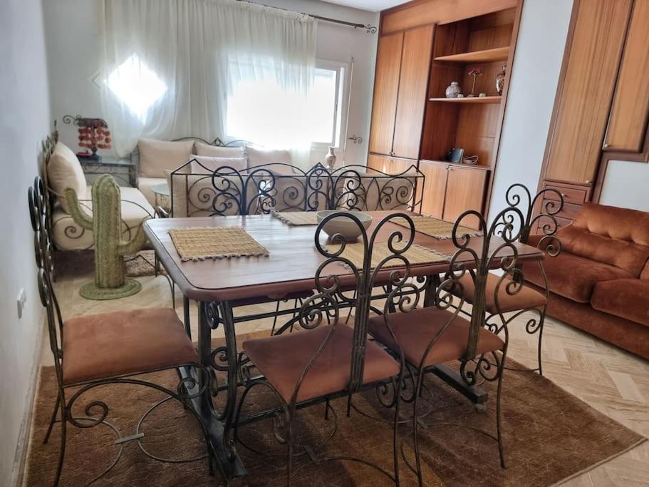 a dining room table and chairs in a living room at Authentic moroccan apartment in Rabat