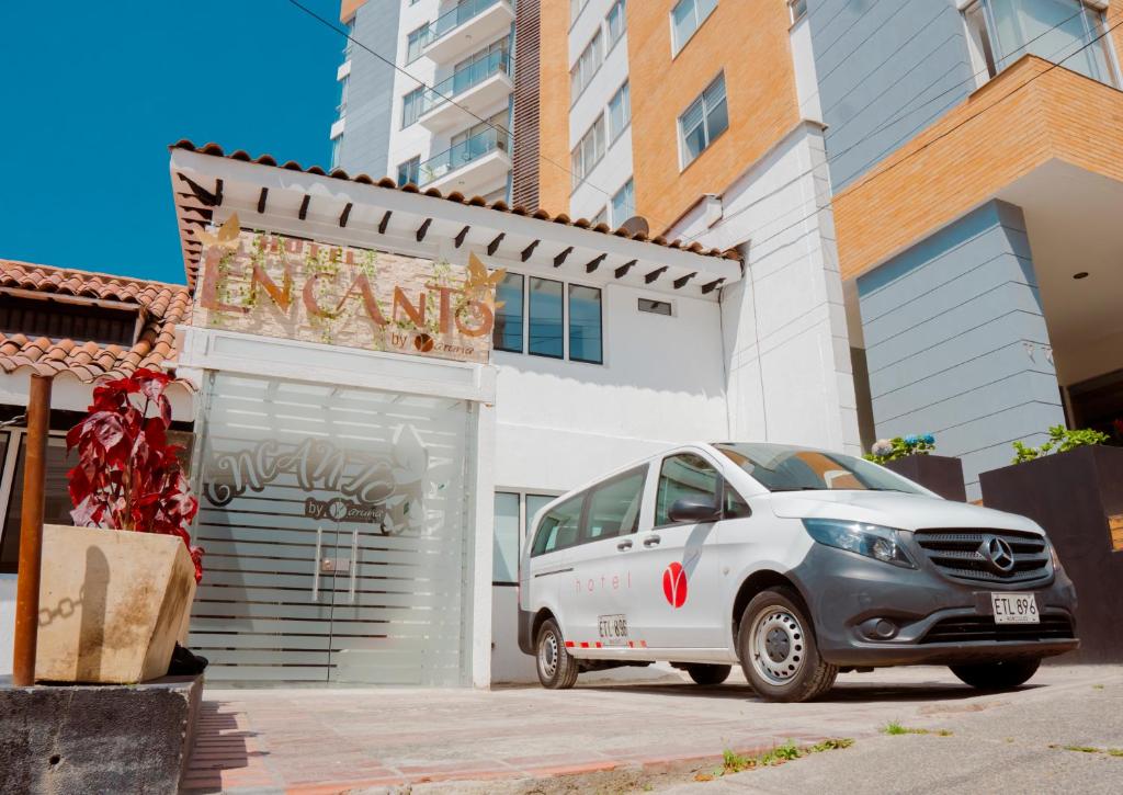 a white car parked in front of a building at Hotel Encanto in Manizales