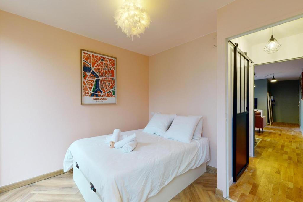 a bedroom with a bed with white sheets and a chandelier at LOVE ROOM with jacuzzi and beautiful terrace in Toulouse