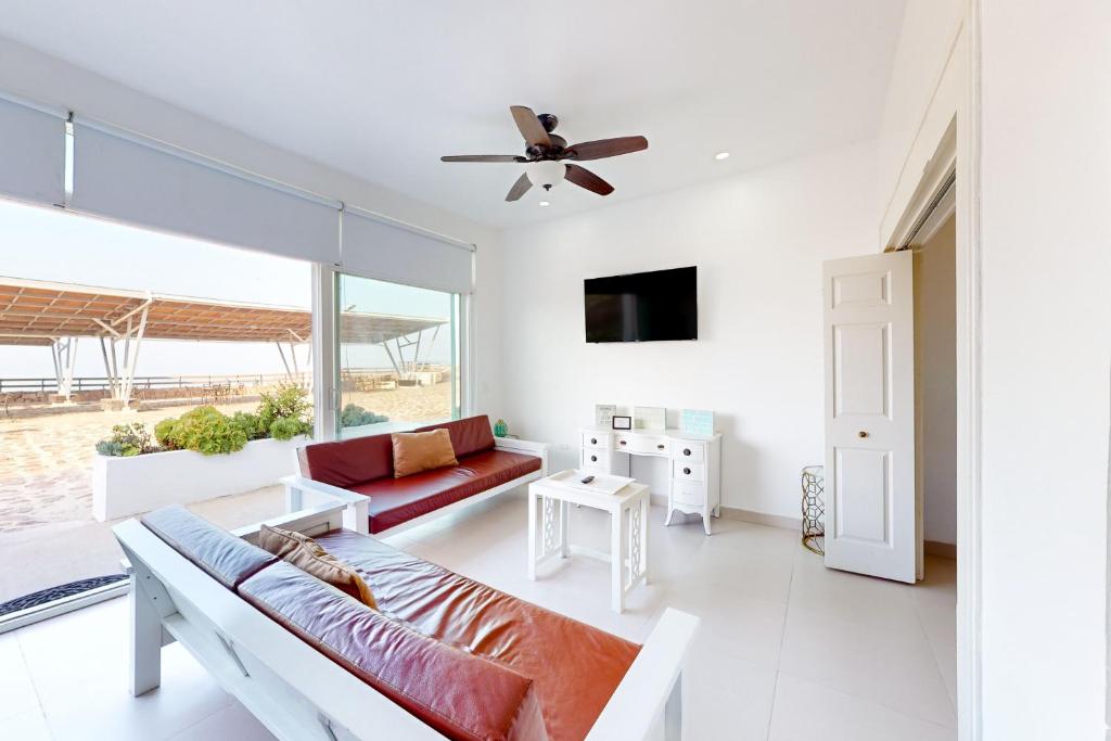 een woonkamer met een bank en een plafondventilator bij Villa Turquesa 56 - Playa Arcangel in Rosarito