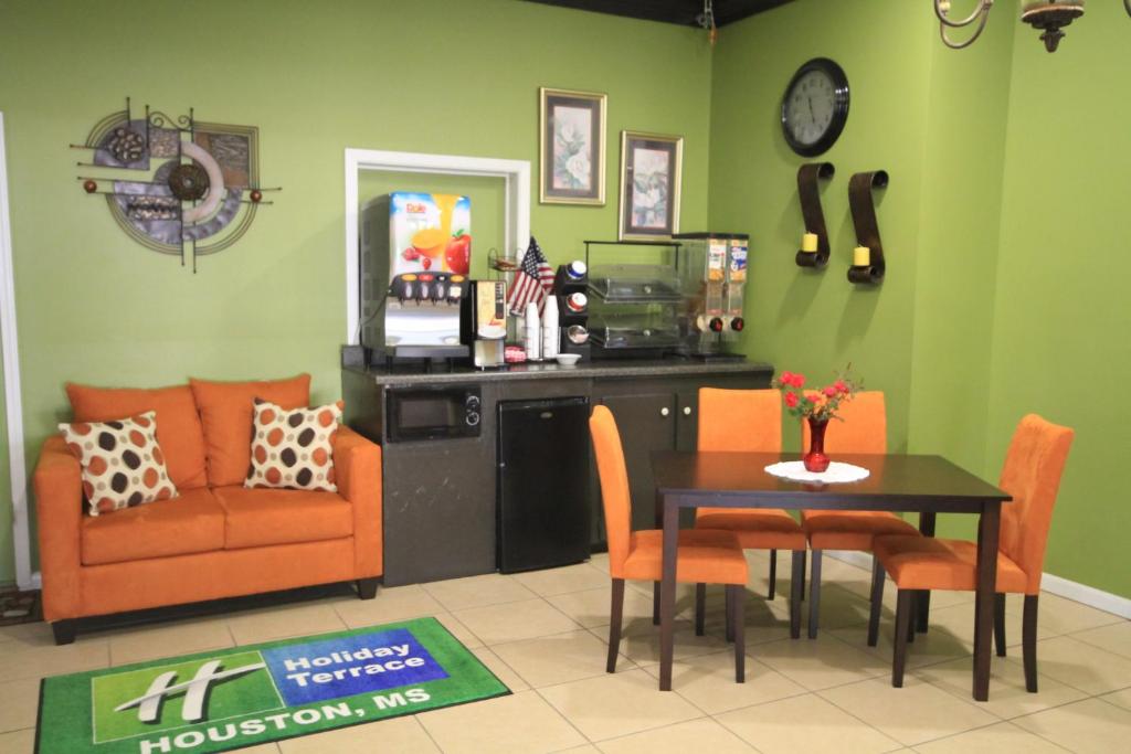 a living room with a table and chairs and a couch at Holiday Terrace Motel in Houston