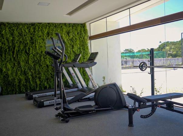 um ginásio com duas bicicletas de exercício e uma parede verde em Muro Alto-Porto de Galinhas Flat Makia 104D em Ipojuca