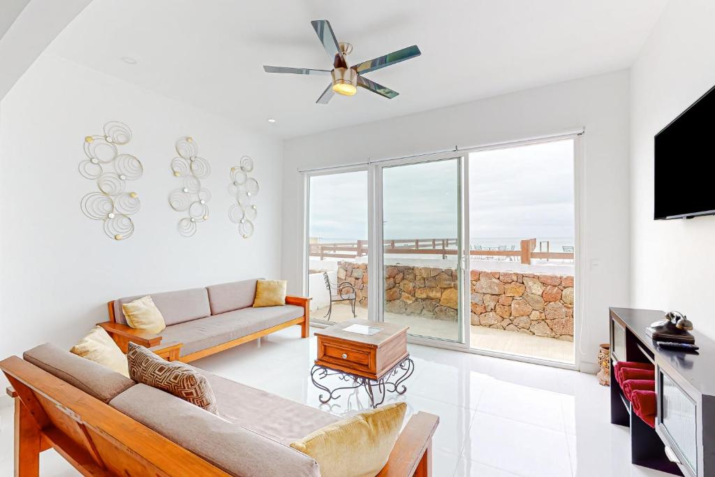 a living room with a couch and a ceiling fan at Casa Roble 24 - Playa Arcangel in Rosarito