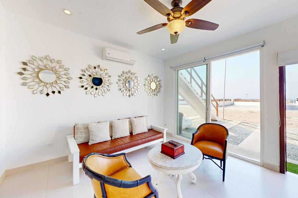 a living room with a couch and chairs and a ceiling fan at Casa Blanca 44 - Playa Arcangel in Rosarito