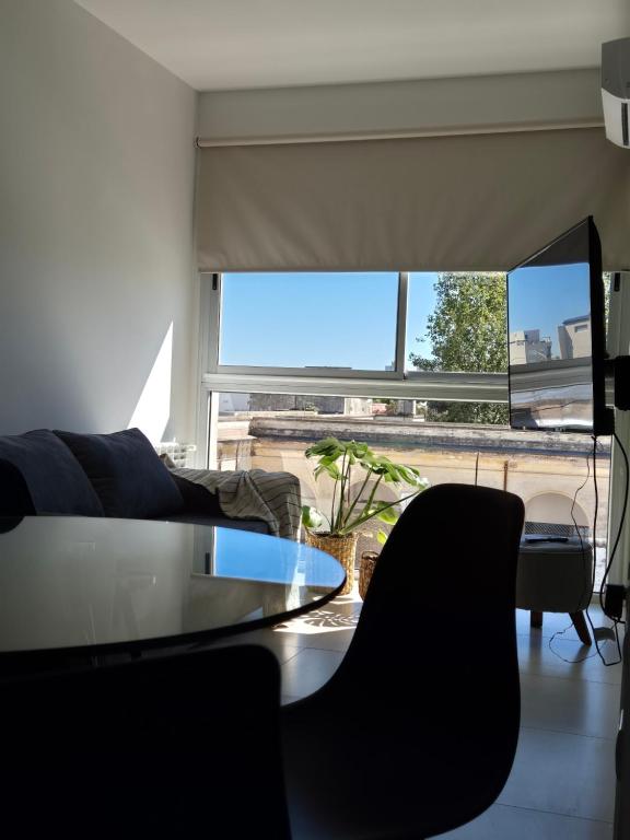sala de estar con mesa, sillas y ventana grande en BHIaparts-Roca con COCHERA en Bahía Blanca