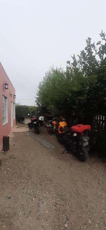 un groupe de motocycles garés à côté d'une maison dans l'établissement Hospedaje PIEDRA BUENA, à Comandante Luis Piedrabuena