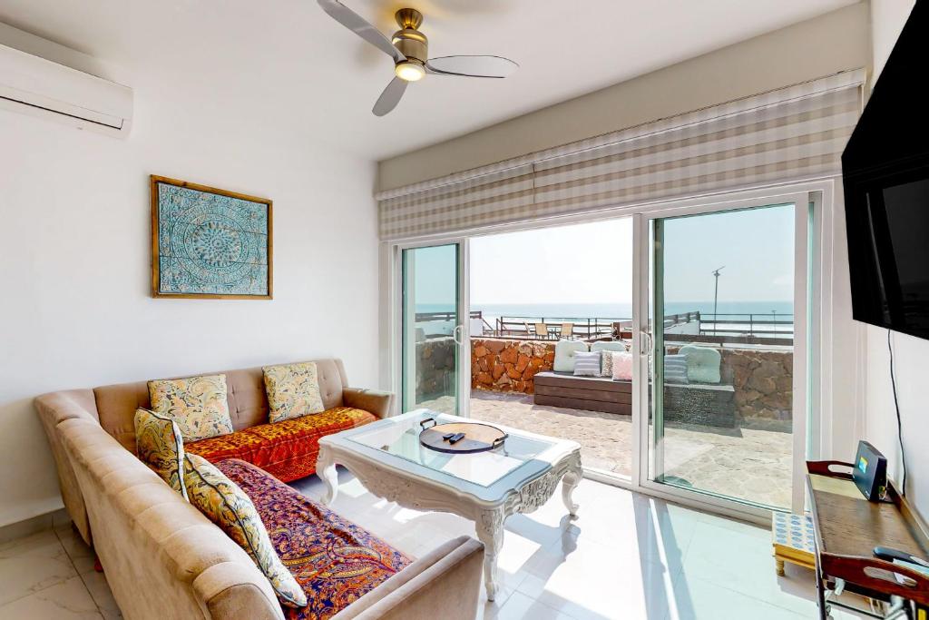 uma sala de estar com um sofá e uma mesa em Villa 19 - Playa Arcangel em Rosarito