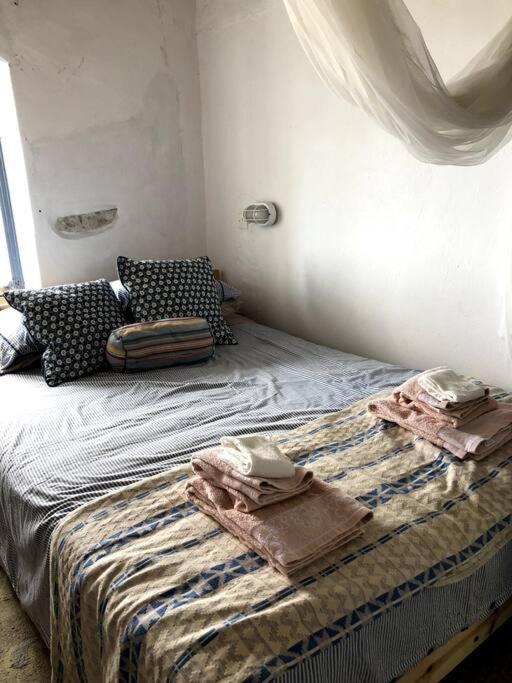 una camera da letto con un letto con asciugamani sopra di School House with Panoramic View a Serifos Chora