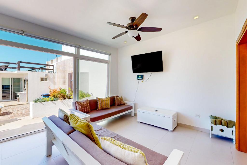 a living room with a couch and a flat screen tv at Villa Olivo 45 - Playa Arcangel in Rosarito