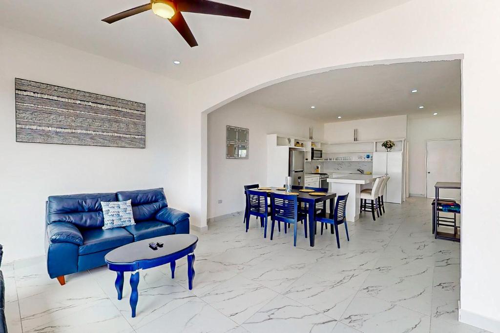 a living room with a blue couch and a table at Casa 12 - Playa Arcangel in Rosarito