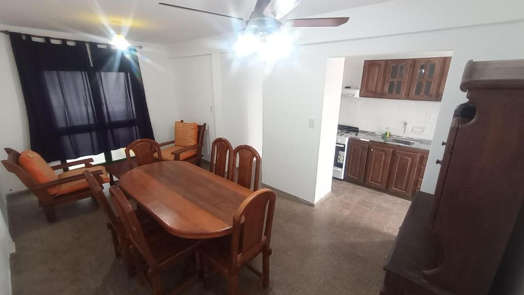 Una cocina y un comedor con mesa y sillas de madera. en COMPLEJO MAINUMBI BARRIO Hipotecario, en Mercedes