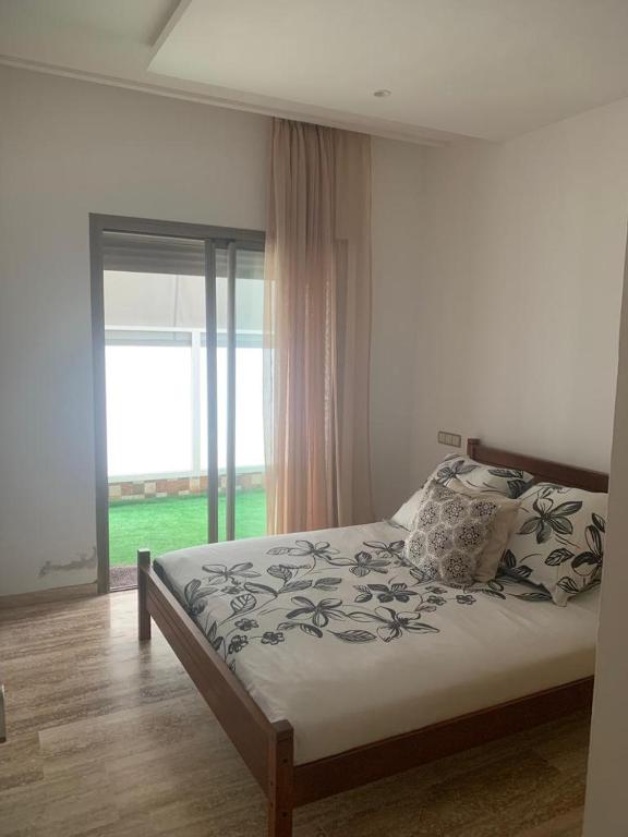 - une chambre avec un lit et une grande fenêtre dans l'établissement Belle Appartement Harhoura, à Oulad Kerroum