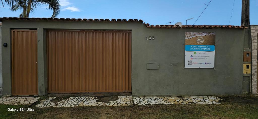 a building with a gate and a sign on it at Casa temporada Guriri in São Mateus
