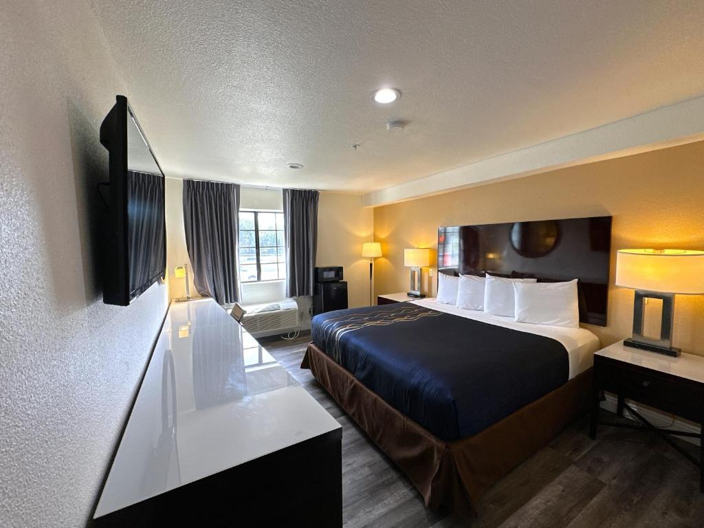Habitación de hotel con cama y TV en Vista Inn, en Vista