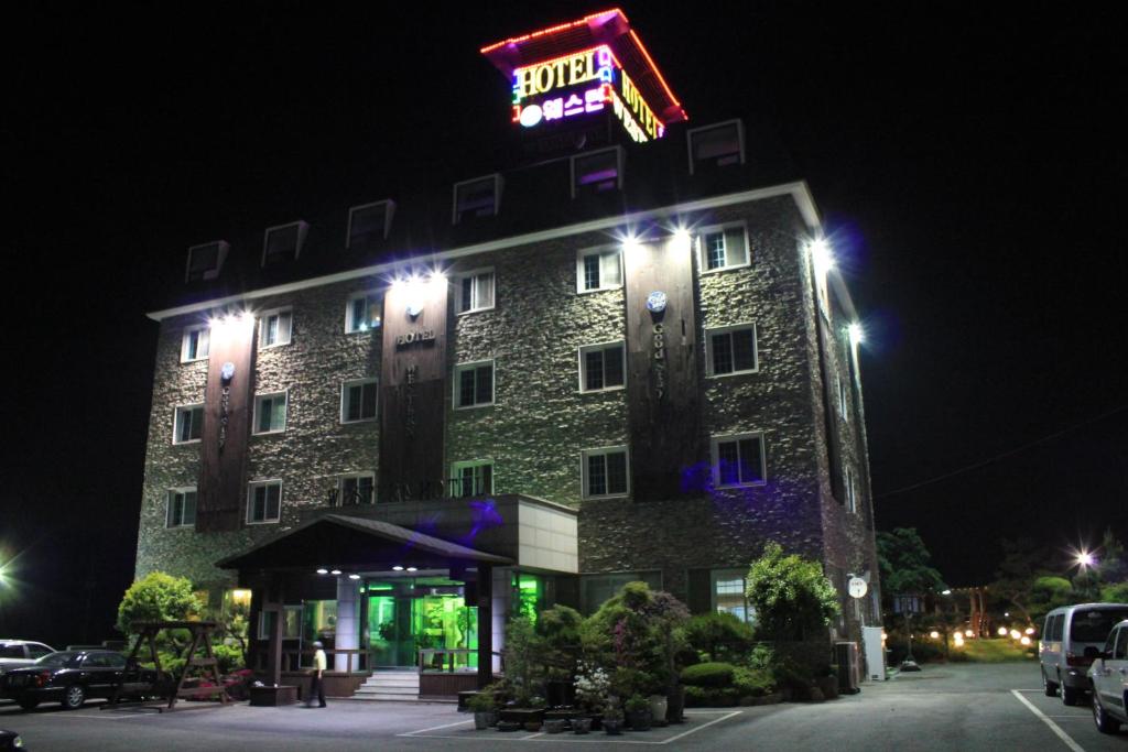 a building with a sign on top of it at night at Gunsan Western Hotel in Gunsan-si