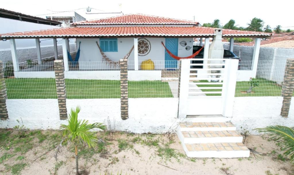 una casa blanca con una puerta y un patio en CASA PARRACHO Maracajaú en Maxaranguape