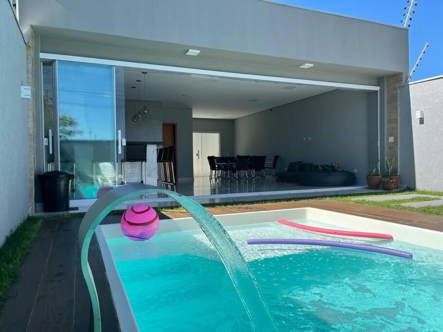 uma piscina com uma fonte em frente a uma casa em Chácara Espanha em Maringá
